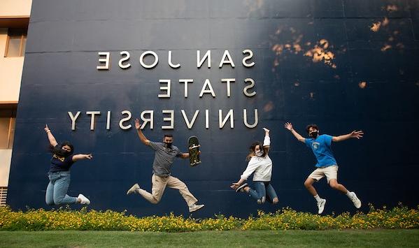 菠菜网lol正规平台的学生们在“圣何塞州立大学”的标志前高兴地跳了起来